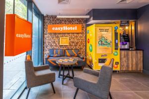 a cafe with a vending machine and a table and chairs at easyHotel London City Shoreditch in London