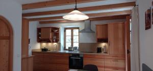 a kitchen with wooden cabinets and a black stove at Wohnen beim Keramiker in Kolbermoor