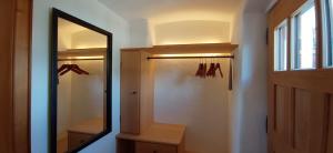 a hallway with a mirror and a closet with hangers at Wohnen beim Keramiker in Kolbermoor +7 photos