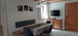 a dining room with a table with chairs and a television at Wohnen beim Keramiker in Kolbermoor
