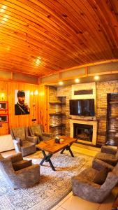 a living room with a table and a fireplace at Goblec Otel in Uzungöl