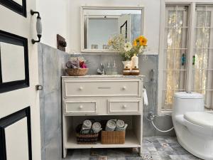 a bathroom with a white dresser and a sink at Crepe Ginger Home Stays in Hariharpur