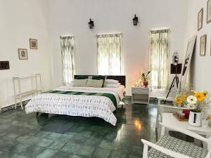 a white bedroom with a bed and flowers in it at Crepe Ginger Home Stays in Hariharpur +13 photos