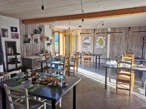 a dining room with tables and chairs in a restaurant at Le Moulin de la Fortie, maison d'hôtes in Viscomtat