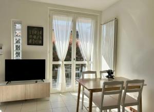 a dining room with a television and a table and chairs at Bellagio Wave Apartment in Bellagio