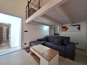 a living room with a blue couch and a table at La casa della nonna by LoveSud in Castrignano del Capo