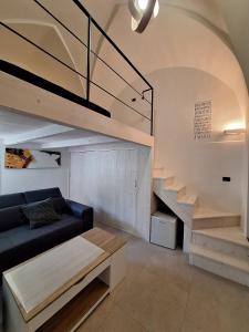 a living room with a black couch and stairs at La casa della nonna by LoveSud in Castrignano del Capo