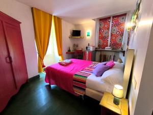 a bedroom with a large bed with a red blanket at Hotel L'Astrolabe in Oloron-Sainte-Marie
