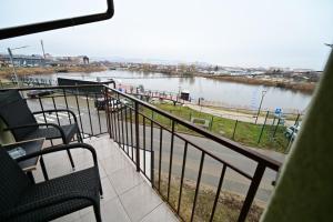 a balcony with chairs and a view of a river at FLH - Binder Lake View with AC in Sibiu