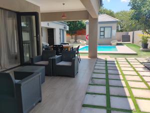 a patio with chairs and a table and a pool at Petalite villa in Maun