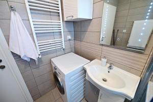 a bathroom with a sink and a washing machine at FLH - Binder Lake View with AC in Sibiu +58 photos