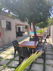a patio with tables and chairs under a tree at Petalite villa in Maun