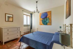 a bedroom with a blue bed and a painting on the wall at "Villa Bizzi" in Monte Castelli +73 photos
