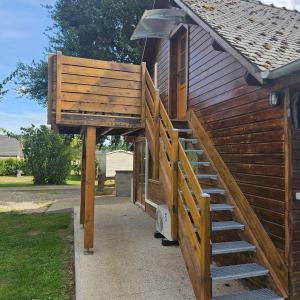 a wooden staircase leading up to a house at Hébergement Cosy in Bourg-et-Comin