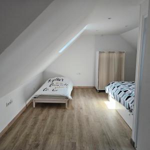 a attic room with a mattress and a bed in it at Hébergement Cosy in Bourg-et-Comin +3 photos