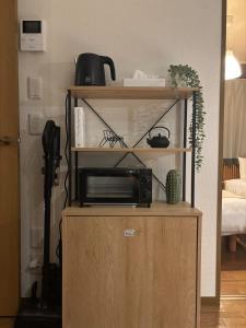 a wooden cabinet with a microwave on top of it at Matsudo in Matsudo
