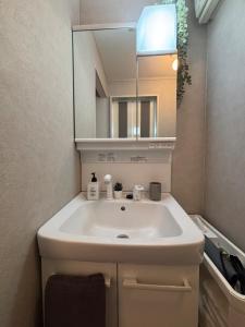a bathroom with a white sink and a mirror at Matsudo in Matsudo +18 photos