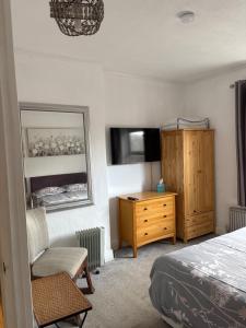 a bedroom with a bed and a dresser and a mirror at Crispin House in Hunstanton