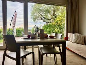 a dining room with a table and chairs and a large window at Respiro di Tramonto in Montegranaro