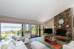 a living room with a fireplace and a tv at 10 Kanangra Crescent - Entire in Jindabyne