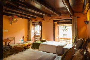 a room with two beds and a window with a window at Bandipur Bazar Ghar in Bandipur