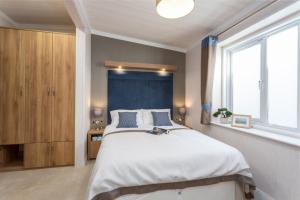 a bedroom with a large bed and a large window at Lyndale Lodge in Pulrossie