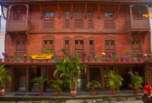 a brick building with potted plants on it at Bandipur Bazar Ghar in Bandipur +4 photos