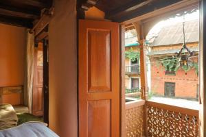 an open door to a balcony with a window at Bandipur Bazar Ghar in Bandipur