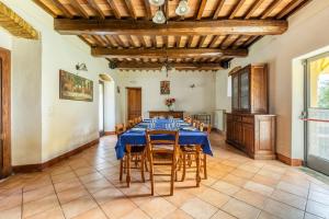 a large dining room with a blue table and chairs at "Villa Bizzi" in Monte Castelli