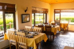 a dining room with tables and chairs and windows at Slieve Elva B&B in Lisdoonvarna