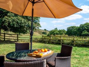a table with an umbrella with a tray of fruit on it at 2 Bed in Crediton oc-72791 in Coldridge
