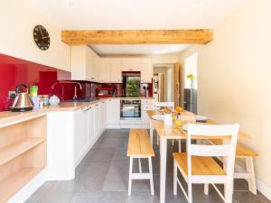 a kitchen with white cabinets and a table and chairs at 2 Bed in Crediton oc-72791 in Coldridge +16 photos