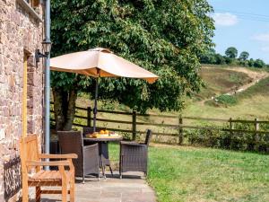 a table and chairs under an umbrella on a patio at 2 Bed in Crediton oc-72791 in Coldridge