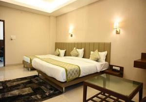 a bedroom with a large bed and a glass table at TTAMAASHA INNN in Chinhat
