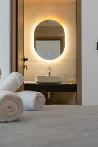 a bathroom with a sink and a bed with towels at Elysian Studio A4 in Karpathos