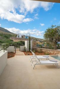a patio with a lounge chair and a pool at Villa Artemis 5 - Etheras Properties in Kythira