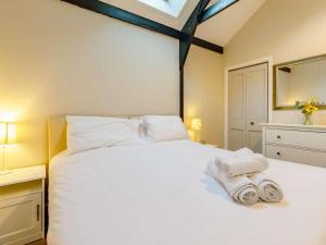 a bedroom with a white bed with towels on it at 2 Bed in Umberleigh oc-09089 in Umberleigh Bridge