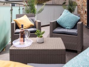 two chairs and a table with a bottle of wine on a patio at 2 Bed in Bideford oc-65074 in Northam +2 photos