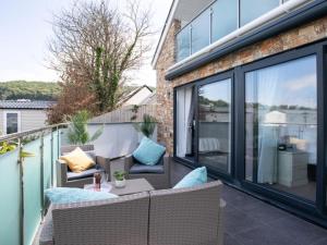 a balcony with a couch and chairs on a balcony at 2 Bed in Bideford oc-65074 in Northam