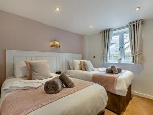 a bedroom with two beds and a window at 2 Bed in Bideford oc-65074 in Northam