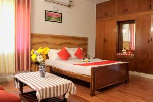 a bedroom with a bed with a vase of flowers on a table at SAS Apartment in Bangalore