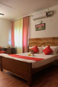 a bedroom with a large bed with red pillows at SAS Apartment in Bangalore