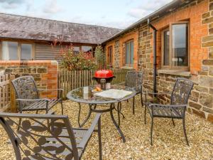 a patio with chairs and a table and a grill at 2 Bed in Umberleigh oc-09091 in Umberleigh Bridge