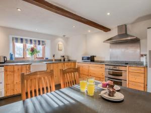 a kitchen with a table with two glasses of orange juice at 2 Bed in Tiverton oc-77442 in Washfield +16 photos