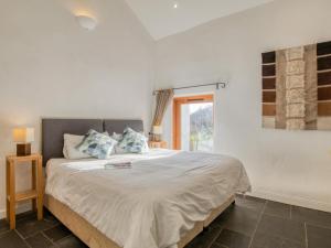 a white bedroom with a large bed with blue pillows at 2 Bed in Tiverton oc-77442 in Washfield