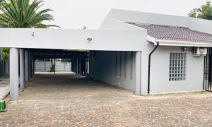 a white house with a garage and a driveway at Fourways Luxury Residence in Four Ways