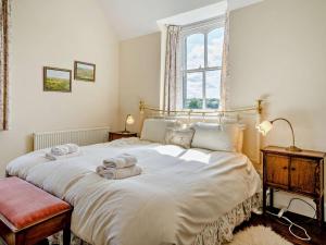 a bedroom with a large white bed with towels on it at 3 Bed in Brecon oc-bn134 in Brecon