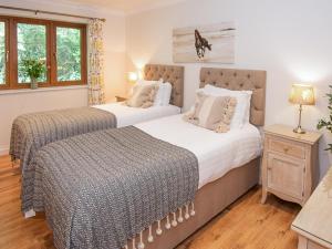 two beds in a bedroom with two windows at 3 Bed in Bideford oc-89865 in Westward Ho