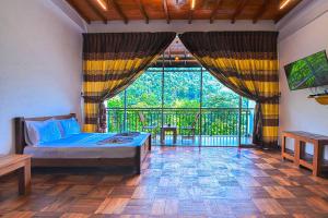 a bedroom with a bed and a large window at Kitulgala Ebony Riverside Resort in Kitulgala +65 photos