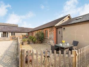 a brick house with a wooden fence in front of it at 1 Bed in Umberleigh oc-09090 in Umberleigh Bridge